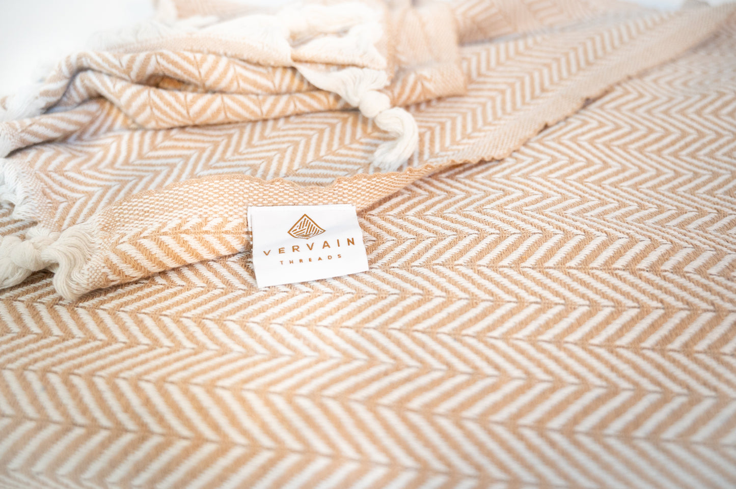 A close up shot of the cotton herringbone throw blanket with the label showing.