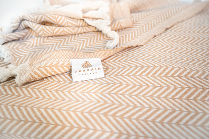 A close up shot of the cotton herringbone throw blanket with the label showing.