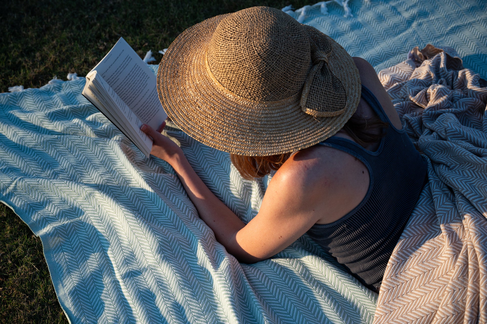 Another perspective of a woman reading with the palmetto green color visible under the natural sunlight.