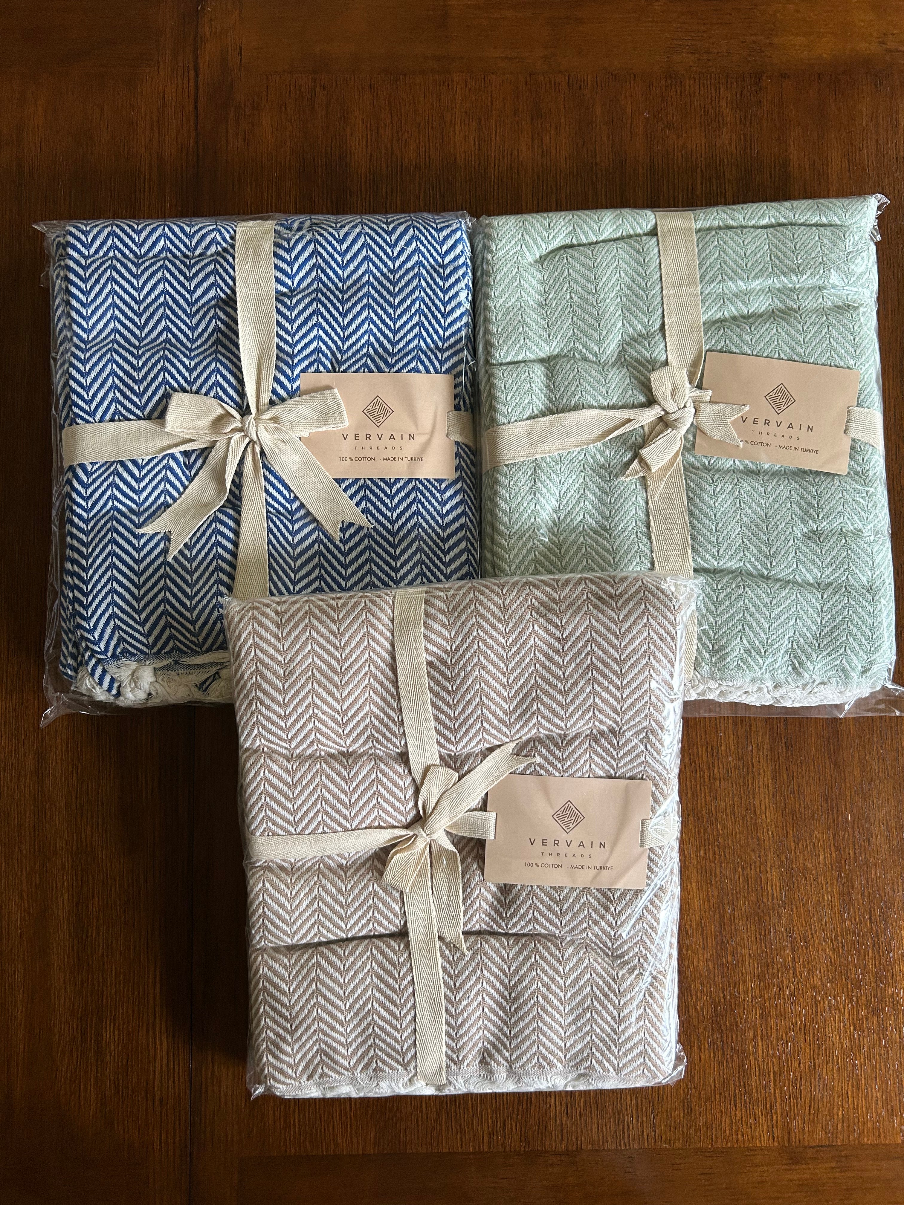 Three Vervain Threads blankets tied with ribbon and brand cards